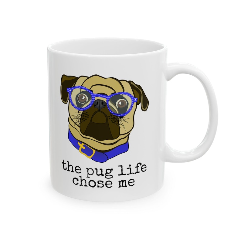 Puede incluir: Taza de cer&aacute;mica blanca con un pug de dibujos animados que lleva gafas azules y un collar azul. El texto "the pug life chose me" est&aacute; impreso en la taza.