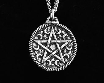 May include: A silver chain necklace with a round pendant featuring a five-pointed star with crescent moons around the perimeter.