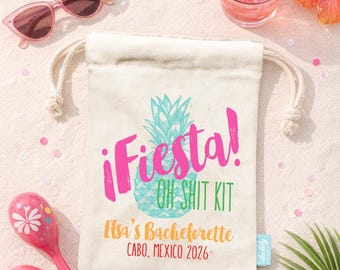 Puede incluir: Una bolsa de lona color crema con cordón, un gráfico de piña turquesa y el texto ¡Fiesta! OH SHIT KIT, Elsa's Bachelorette, CABO, MEXICO 2026. La bolsa está rodeada de gafas de sol rosas, dos maracas rosas, una rodaja de lima y una bebida.