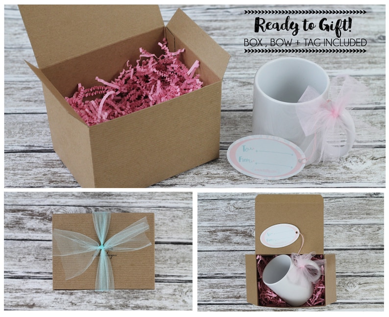 May include: A white ceramic mug with a pink ribbon and a gift tag that says "To my favorite..." is packaged in a brown cardboard box with pink tissue paper. The box is tied with a blue ribbon. The text "Ready to Gift! BOX, BOW + TAG INCLUDED" is displayed above the image.