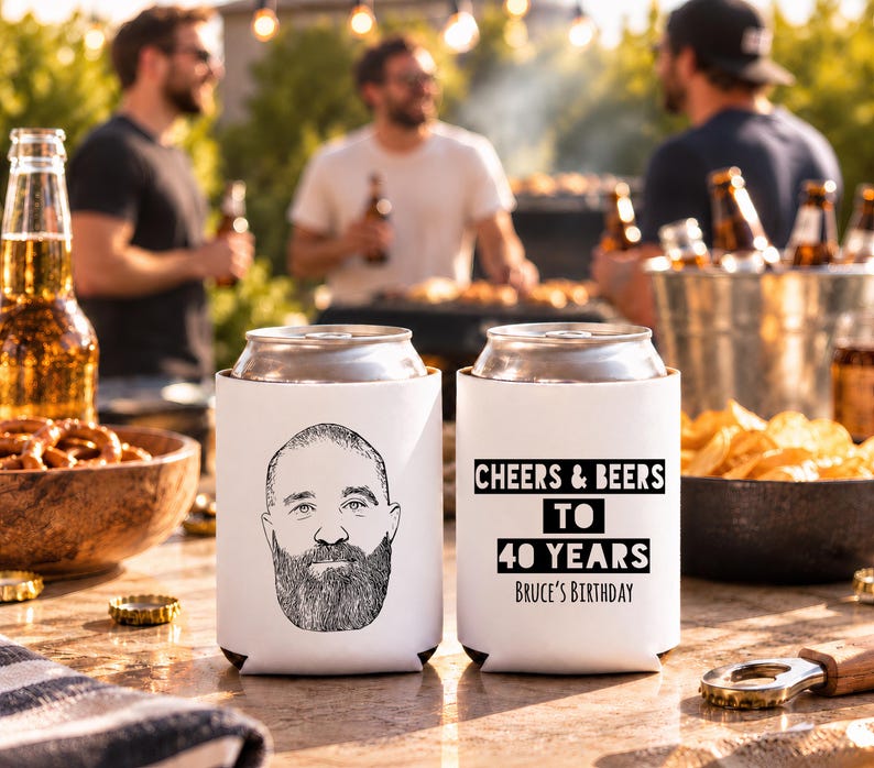 May include: Two white foam can coolers. One features a black line drawing of a bearded man's face. The other displays the black text: CHEERS & BEERS TO 40 YEARS BRUCE'S BIRTHDAY. The coolers are cylindrical with open tops and bottoms.