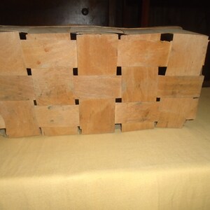 K&ouml;nnte beinhalten: Ein rechteckiger geflochtener Korb aus Holz. Der Korb besteht aus d&uuml;nnen Holzstreifen, die miteinander verflochten sind, um ein Gittermuster zu bilden. Der Korb ist leer und hat eine hellbraune Farbe.