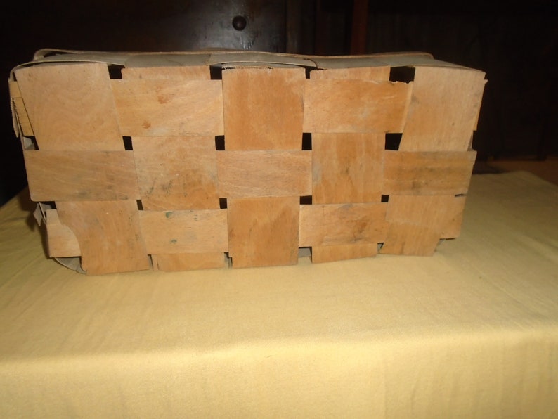 K&ouml;nnte beinhalten: Ein rechteckiger geflochtener Korb aus Holz. Der Korb besteht aus d&uuml;nnen Holzstreifen, die miteinander verflochten sind, um ein Gittermuster zu bilden. Der Korb ist leer und hat eine hellbraune Farbe.