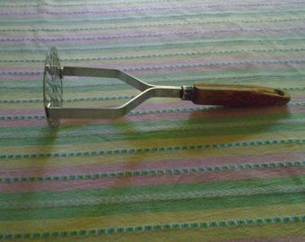 Machacador de patatas redondo de acero inoxidable con mango de madera, estilo vintage de la marca Ekco Forge.