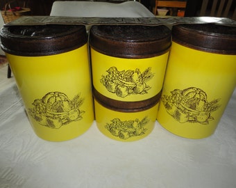 May include: Set of three yellow canisters with brown lids and black fruit and wheat designs.