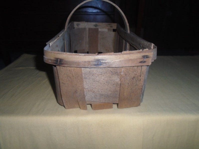 K&ouml;nnte beinhalten: Ein Holzkorb mit Henkel, aus naturbelassenem Holz mit rustikalem Finish.