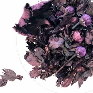 Könnte beinhalten: Eine Schale gefüllt mit getrocknetem violettem und braunem Potpourri. Das Potpourri enthält getrocknete Blumen, Blätter und Beeren.