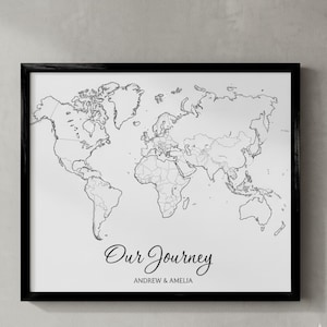 May include: A framed world map print in black and white. The map shows the continents and countries. The text "Our Journey" is written in cursive font, with "ANDREW & AMELIA" below it.