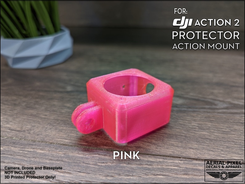 May include: A pink 3D printed protector for a DJI Action 2 camera. The protector is designed to mount the camera to an action mount. The text "FOR: DJI ACTION 2 PROTECTOR ACTION MOUNT" is printed on the image.