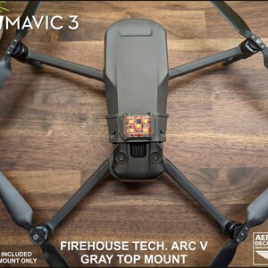 K&ouml;nnte beinhalten: Ein grauer 3D-gedruckter Halter f&uuml;r eine DJI Mavic 3 Drohne. Der Halter ist f&uuml;r einen Blitz ausgelegt, der jedoch nicht im Lieferumfang enthalten ist. Der Halter ist mit "Firehouse Tech. Arc V Gray Top Mount" beschriftet.