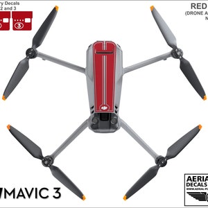 May include: Red and gray vinyl decals for a DJI Mavic 3 drone. The decals include a red stripe down the center of the drone and a gray stripe on each side. The decals also include numbered battery decals for the drone's batteries.