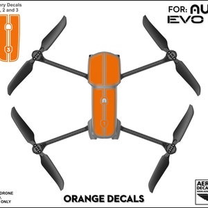 Pu&ograve; includere: Adesivi in ​​vinile arancioni per un drone Autel EVO Lite+. Gli adesivi coprono il corpo del drone e la batteria. Gli adesivi sono numerati 1, 2 e 3.