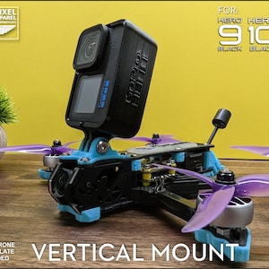 May include: A black GoPro camera mounted on a blue and black drone frame with purple propellers. The text "VERTICAL MOUNT" is displayed below the drone. The image also includes the text "FOR: HERO 9 10 11 BLACK BLACK BLACK".