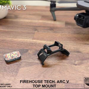 K&ouml;nnte beinhalten: Ein schwarzer 3D-gedruckter Halter f&uuml;r eine DJI Mavic 3 Drohne. Der Halter ist mit "FIREHOUSE TECH. ARC V TOP MOUNT" beschriftet.