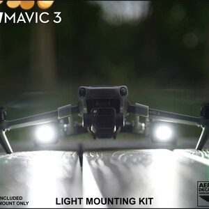 K&ouml;nnte beinhalten: Eine dunkelgraue DJI Mavic 3 Drohne mit hellwei&szlig;en Lichtern und gr&uuml;nen Lichtern an den Beinen. Der Text "LIGHT MOUNTING KIT" wird unter der Drohne angezeigt. Der Text "FOR: DJI MAVIC 3" befindet sich oben.