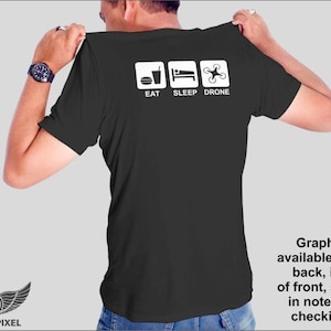 May include: Black t-shirt with a white graphic that says "Eat Sleep Drone" with icons of a burger, a bed, and a drone.