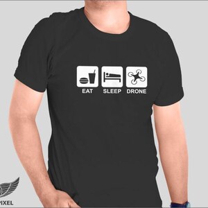 May include: Black t-shirt with white text and icons that say "Eat, Sleep, Drone".