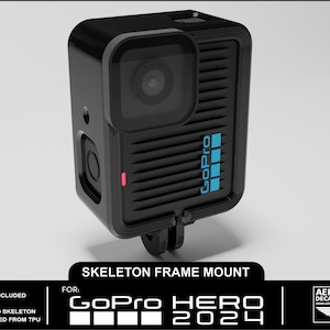 Może przedstawiać: Czarny uchwyt ramy szkieletowej GoPro Hero 2024. Rama ma prostokątny kształt z obiektywem i logo GoPro w kolorze niebieskim. Rama jest przeznaczona do trzymania kamery. Widoczny jest tekst "Skeleton Frame Mount".