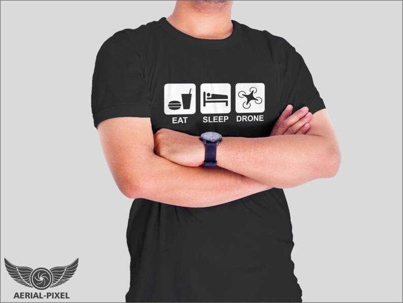 May include: A black t-shirt with a white graphic that says "Eat, Sleep, Drone". The graphic features icons for food, sleep, and a drone.