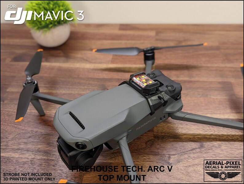K&ouml;nnte beinhalten: Ein 3D-gedruckter Halter f&uuml;r eine DJI Mavic 3 Drohne. Der Halter ist schwarz und hat ein kleines, orangefarbenes Stroboskoplicht angebracht. Der Text "FIREHOUSE TECH. ARC V TOP MOUNT" ist auf dem Halter aufgedruckt. Der Text "STROBE NOT INCLUDED 3D PRINTED MOUNT ONLY" ist unter dem Halter aufgedruckt.