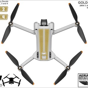 K&ouml;nnte beinhalten: Goldene Aufkleber f&uuml;r eine DJI Mini 3 Pro Drohne. Die Aufkleber sind goldfarben und haben eine strukturierte Oberfl&auml;che. Die Aufkleber sind so konzipiert, dass sie auf den Rumpf und die Propeller der Drohne passen. Das Bild zeigt auch einen Satz nummerierter Akku-Aufkleber.