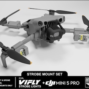 May include: A gray drone with black propellers and strobe light mounts. The image includes text that reads "STROBE MOUNT SET" and "VIFLY + DJI MINI 5 PRO". The drone is shown against a white background. The strobe light and drone are not included.