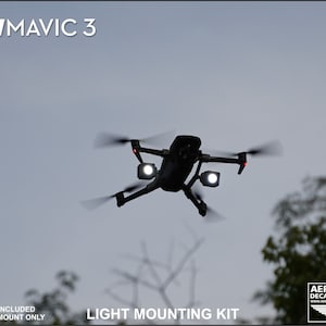 K&ouml;nnte beinhalten: Eine schwarze Drohne mit wei&szlig;en Lichtern im Flug vor einem bew&ouml;lkten Himmel. Der Text "LIGHT MOUNTING KIT" ist zu sehen. Der Text "FOR: DJI MAVIC 3" und "LIGHTS NOT INCLUDED 3D PRINTED MOUNT ONLY" sind ebenfalls vorhanden.