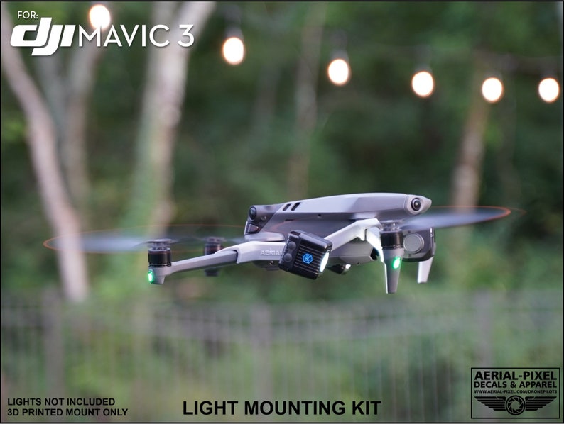 K&ouml;nnte beinhalten: Eine graue DJI Mavic 3 Drohne mit sich drehenden Propellern und gr&uuml;nen Lichtern. Die Drohne hat einen Lichtmontagesatz angebracht. Der Text auf dem Bild lautet "FOR: DJI MAVIC 3" und "LIGHT MOUNTING KIT". Der Hintergrund ist verschwommen mit Bokeh-Lichtern.