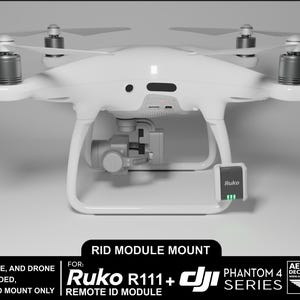 May include: White drone with a black camera and a black Ruko R11+ Remote ID Module attached to the bottom. The drone is labelled "Phantom 4 Series" and "Aerial-Pixel Decals & Apparel".