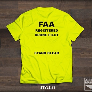 May include: A bright yellow t-shirt with black text that reads "FAA Registered Drone Pilot" and "Stand Clear". The shirt is a style #1.
