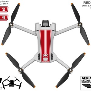 K&ouml;nnte beinhalten: Rote und wei&szlig;e Vinyl-Aufkleber f&uuml;r eine DJI Mini 3 Pro Drohne. Die Aufkleber haben rote Rennstreifen und einen wei&szlig;en Hintergrund. Die Aufkleber sind so konzipiert, dass sie auf den K&ouml;rper und die Arme der Drohne geklebt werden k&ouml;nnen. Das Bild zeigt auch einen Satz nummerierter Akku-Aufkleber.
