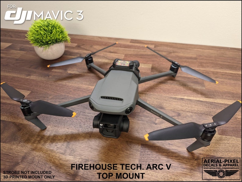 K&ouml;nnte beinhalten: Eine schwarz-graue Drohne mit orangefarbenen Akzenten, beschriftet mit "MAVIC 3", ist auf einem 3D-gedruckten Oberteil montiert. Die Halterung ist mit "FIREHOUSE TECH. ARC V TOP MOUNT" beschriftet.