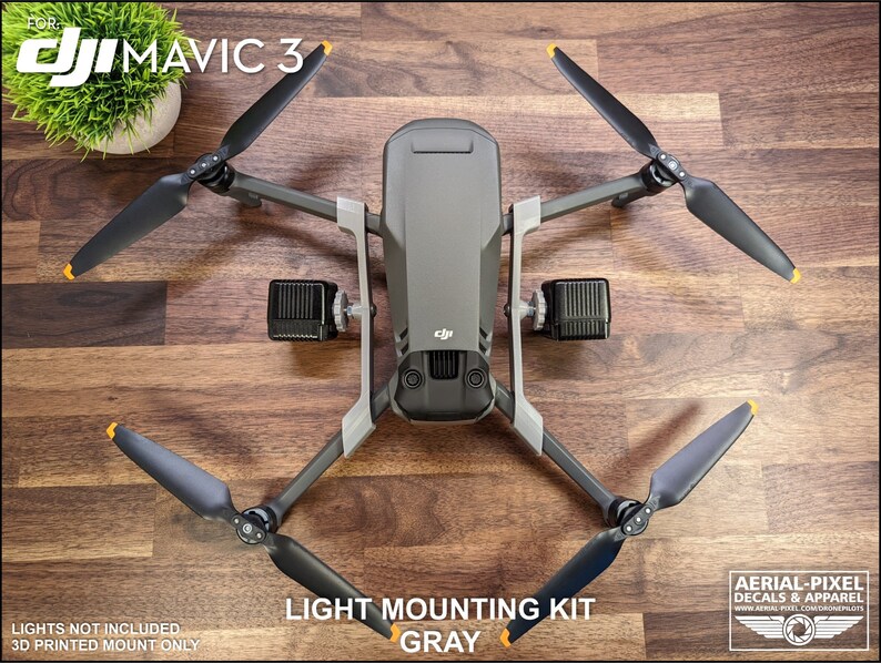 K&ouml;nnte beinhalten: Eine graue DJI Mavic 3 Drohne mit schwarzen Propellern und einem Lichtmontagesatz. Die Propeller haben gelbe Spitzen. Der Text "LIGHT MOUNTING KIT GRAY" ist sichtbar. Das Bild enth&auml;lt auch den Text "DJI MAVIC 3".