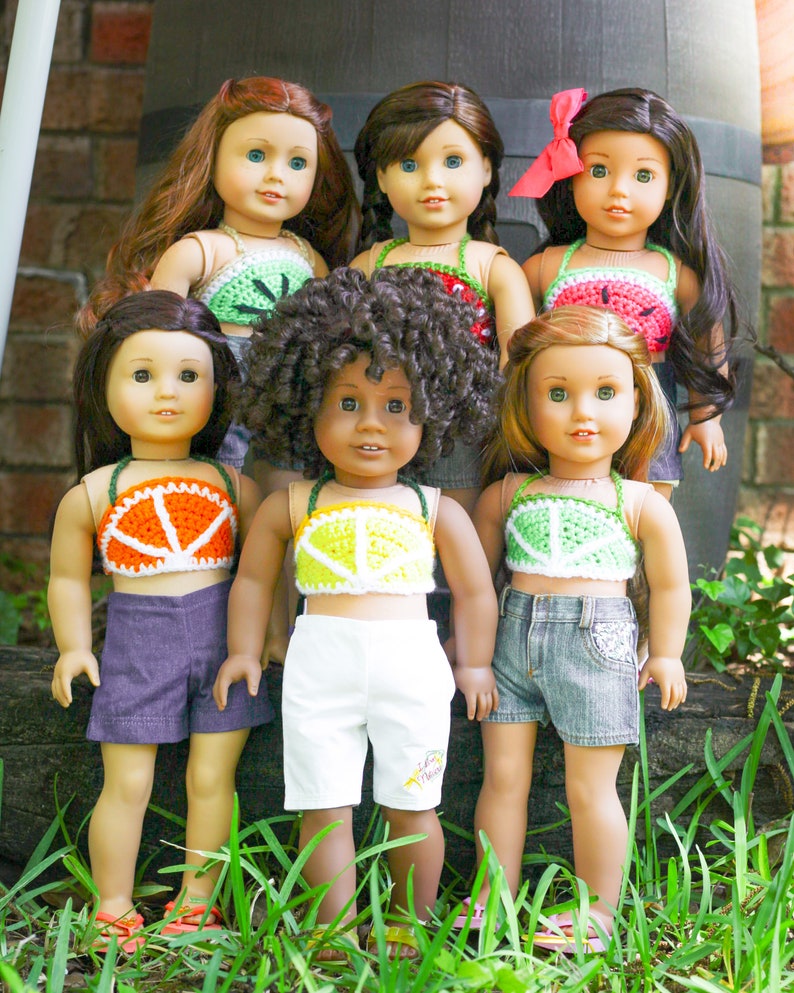 May include: Six dolls wearing crocheted fruit-themed tops. The tops are watermelon, orange, lime, and kiwi. The dolls are wearing various shorts and skirts.