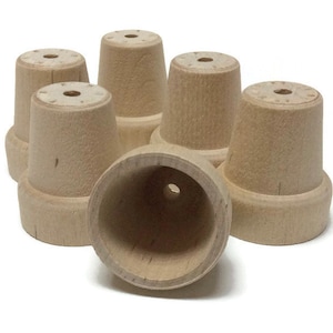 May include: Six unfinished wooden plant pots, with a seventh pot turned upside down, showing the inside of the pot.
