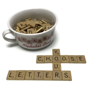 May include: A white ceramic bowl with the words "SCRABBLE Alphabet Soup" printed on it, filled with wooden letter tiles. The tiles are arranged to spell out the words "CHOOSE YOUR LETTERS".