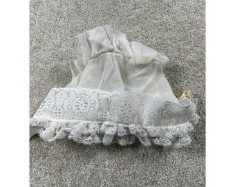 May include: A white vintage baby bonnet with a lace trim and ruffled edge. The bonnet is made of a soft, sheer fabric and has a gathered crown. The lace trim features a delicate floral pattern.