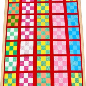以下が含まれることがあります： 鮮やかな赤色の布で仕切られた25個の正方形ブロックのグリッドが特徴の長方形のキルト。各ブロックには、黄色、ピンク、緑、青、白の色合いの様々なカラフルな生地を使用した9パッチのパターンが含まれています。