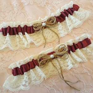 Rustieke vintage bruidsjarretelgordel van bordeauxrood en ivoorkleurig kant met parels en touw.