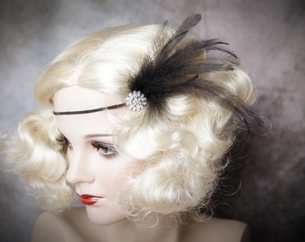 May include: A vintage-style headband featuring a black feather accent and a sparkling rhinestone embellishment. The headband is black and is set against a backdrop of a mannequin with blonde hair and red lipstick, evoking a classic, glamorous aesthetic.