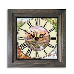 May include: Square wooden wall clock with a rustic gray frame. The clock face features a scenic illustration of deer in a natural landscape with a river and mountains. Roman numerals mark the hours, and black hands indicate the time.