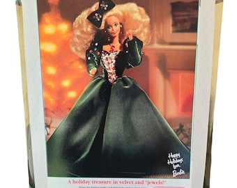 Może przedstawiać: Vintage pudełko dla lalki "Happy Holidays Barbie". Pudełko przedstawia lalkę w zielonej aksamitnej sukni z kokardą i biżuterią. Pudełko ma logo Mattel i tekst "A holiday treasure in velvet and jewels!"