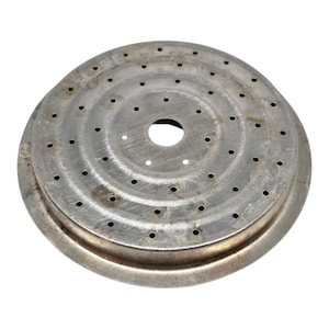 May include: A circular, metal coffee maker filter with numerous small holes. The filter is silver-coloured and shows signs of wear. It has a central hole and a raised edge.