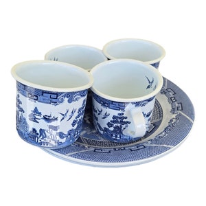 May include: Four blue and white ceramic cups with handles and a matching plate. The cups and plate feature a classic Willow pattern design with scenes of pagodas, bridges, and birds. The set is ideal for serving tea or coffee.