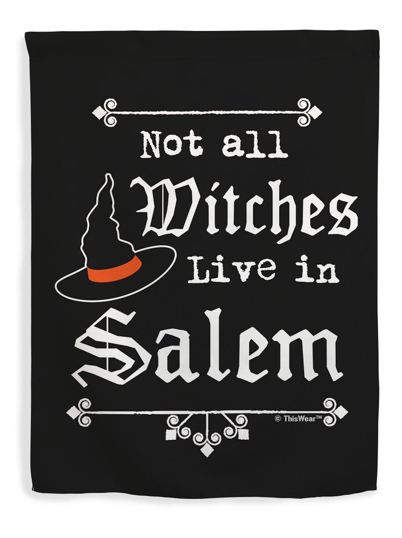 May include: Black flag with white text that reads "Not all Witches Live in Salem." A witch hat with an orange band is featured. Decorative flourishes are at the top and bottom.