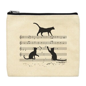 May include: A beige canvas zippered pouch with a black zipper. The pouch features a black silhouette of three cats on a musical staff with the text "ThisWear™" in the bottom right corner.
