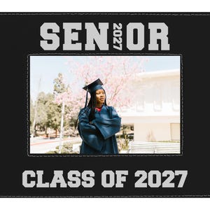 May include: A black rectangular picture frame with white stitching along the inner and outer edges. The top border features the text SENIOR with 2027 vertically between the letters. The bottom border displays the text CLASS OF 2027 in white.