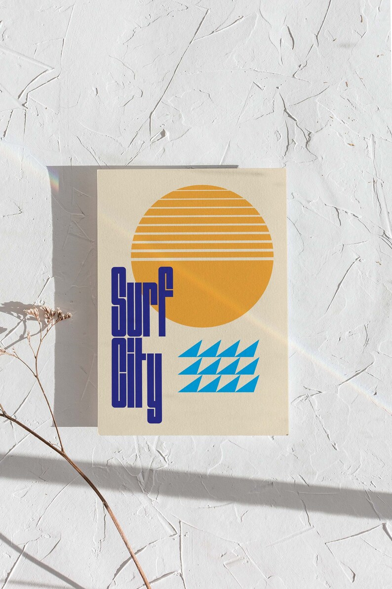 Puede incluir: Una tarjeta beige con un dise&ntilde;o gr&aacute;fico azul y amarillo. El gr&aacute;fico presenta un sol amarillo con rayas naranjas, un patr&oacute;n de olas azul y el texto "Surf City" en azul.