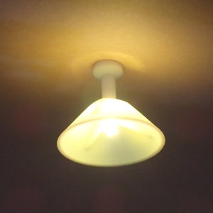 Peut inclure: Un luminaire de plafond blanc avec un abat-jour en forme de cône et une seule ampoule.