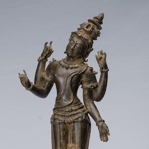 Può includere: Una scultura in bronzo di una divinità indù con quattro braccia, in piedi su una base nera. La divinità indossa una corona e gioielli elaborati.